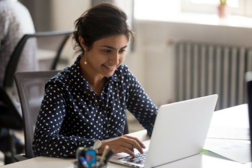 Smiling virtual assistant at a computer using microsoft teams