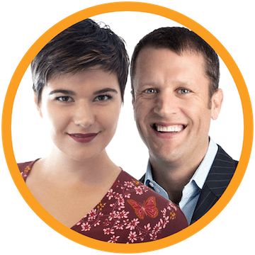 A woman with short, dark hair and a floral top stands next to Charles Pulliam in a suit. Both are smiling warmly within the orange circles embrace.