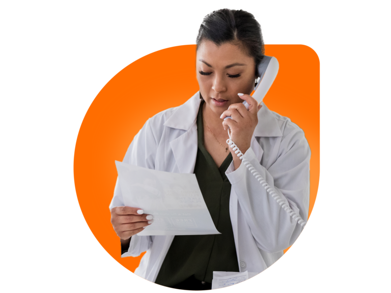 Woman wearing lab coat on the phone while looking at a flier.